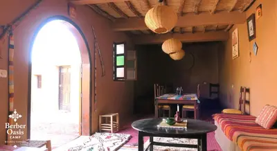 a living room with a table and a couch at Berber Oasis Camp in Kasr Bounou