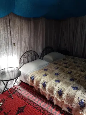 a bedroom with a bed and a table at Desert Camp in Zagora - Camel ride - Easy & Affordable Stays in Zagora