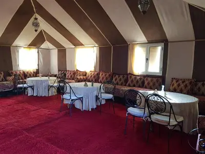 a room with tables and chairs with white table cloth at Desert Camp in Zagora - Camel ride - Easy & Affordable Stays in Zagora
