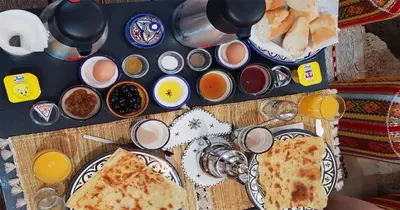 a table with two slices of pizza on plates at Dar Yan in Er Rachidia