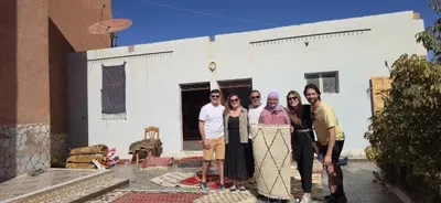 a group of people standing in front of a house at Espace Taznakhte in Tazenakht
