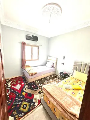 a room with two beds and a window at Espace Taznakhte in Tazenakht