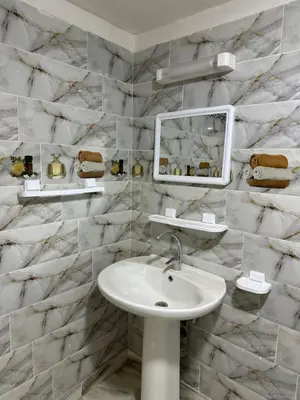 a white bathroom with a sink and a mirror at Espace Taznakhte in Tazenakht