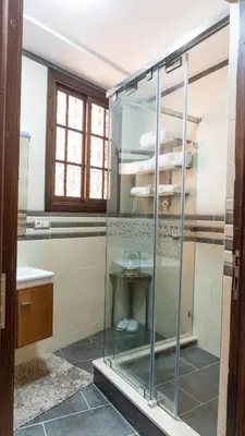 a glass shower in a bathroom with a table at Dar Bouzoubaa in Fès