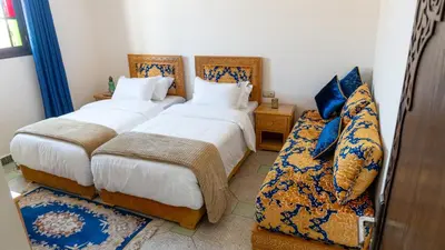 a bedroom with two beds and a couch at Dar Bouzoubaa in Fès