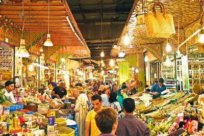 a group of people standing in a market with food at Dar Bouzoubaa in Fès
