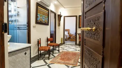 a hallway with a door and chairs in a room at Dar Bouzoubaa in Fès