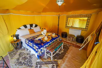 a bedroom with a bed in a tent at Horaz Merzouga Camp in Merzouga
