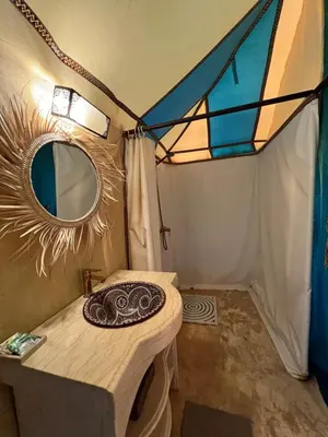 a mirror and a table in a tent at Horaz Merzouga Camp in Merzouga