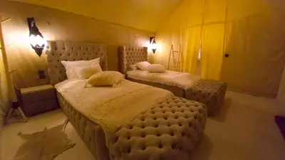 a bedroom with two twin beds in a room at Horaz Merzouga Camp in Merzouga